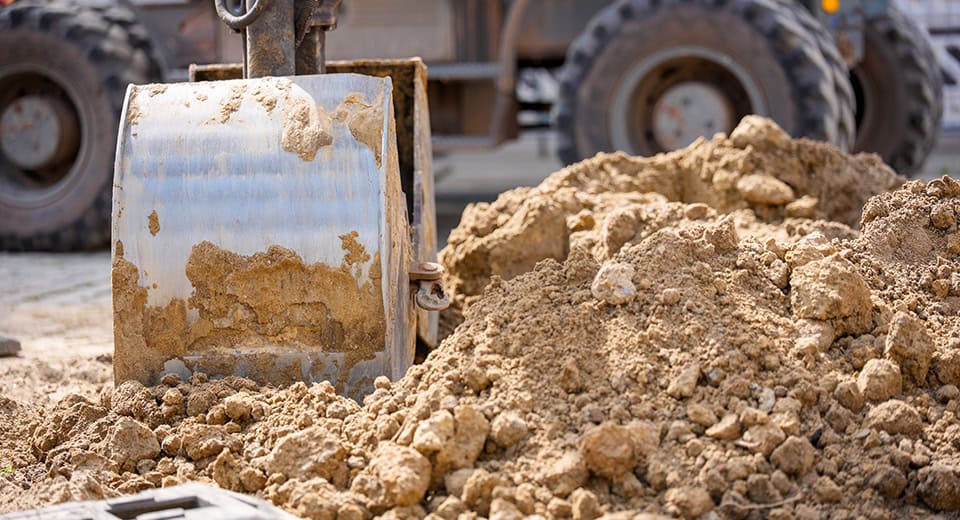 Baggerschaufel im Erdaushub auf einer Tiefbaustelle